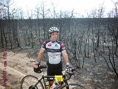 MBike Mike with burnt out forrest from fire